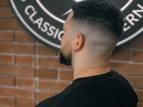 Kręcone włosy z high fade — widok z tyłu — Gentlemen Barber Shop Sanok