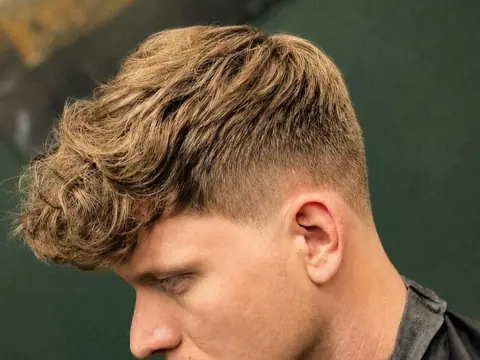 Kręcona grzywka z low fade — Boske Barber Rzeszów