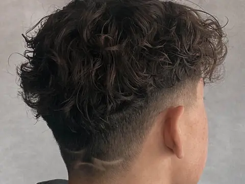 Kręcone włosy z wzorem na karku — Boske Barber Rzeszów