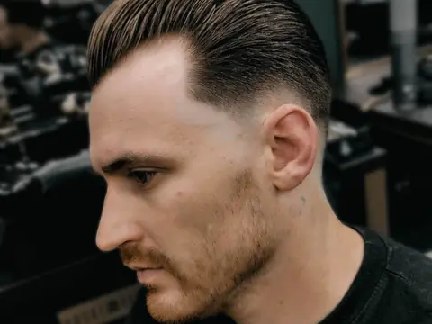 Zaczesana do tyłu fryzura z fade — profil — Boske Barber Rzeszów